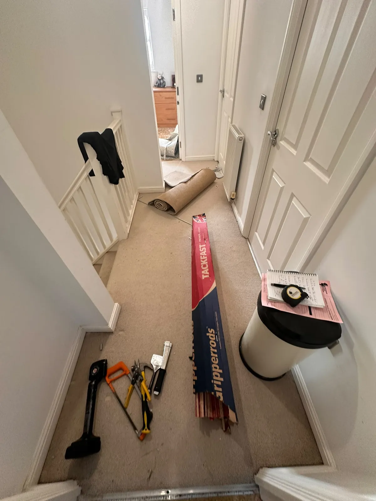 Professional carpet fitting tools, gripper rods and rolled-up old carpet on landing — Bromley BR1