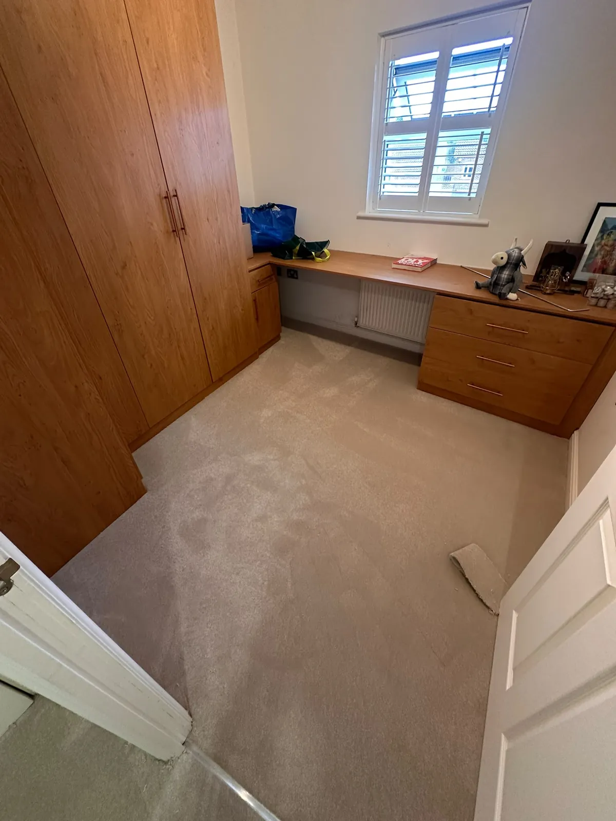 Bedroom with built-in wardrobe and desk showing existing worn carpet before uplift — Bromley BR1