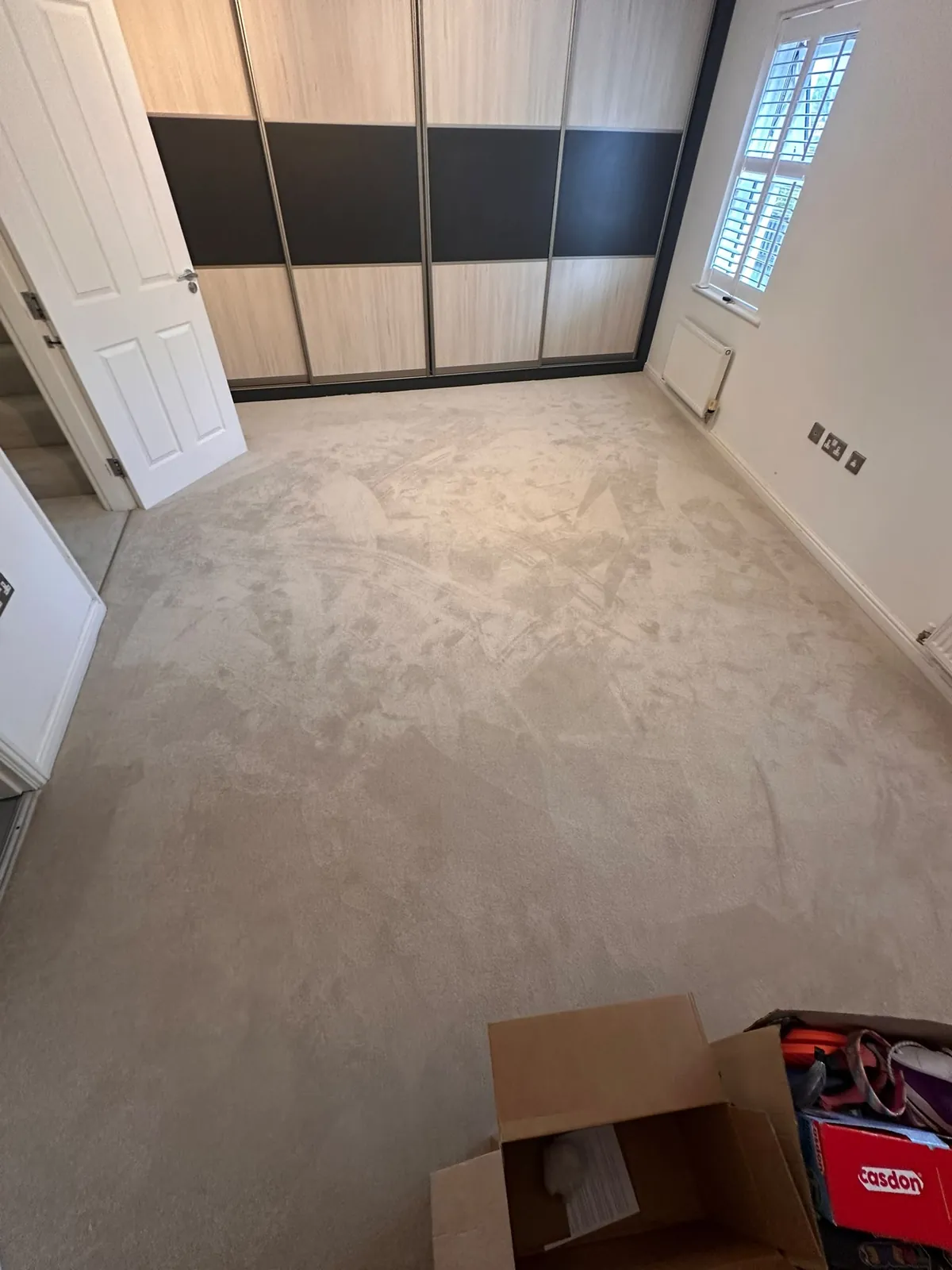 Bedroom with fitted wardrobes showing existing worn carpet before uplift — Bromley BR1